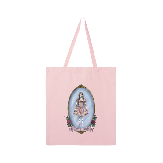 A light pink canvas tote bag with long shoulder straps, featuring a central graphic of a doll in a pink dress inside an oval frame with the text 'Mollie Elizabeth'.